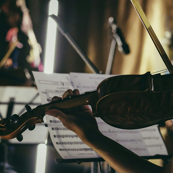Closeup of a person playing the violin in a studio
