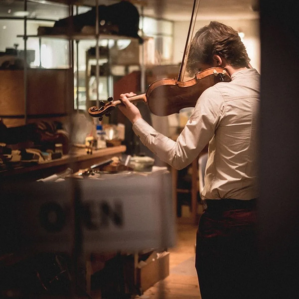 A man standing and playing the violin