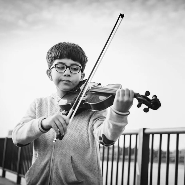 Boy playing violin on the riverfront