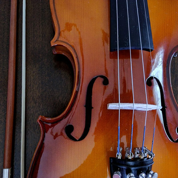 Closeup of a violin and a bow on a wood background
