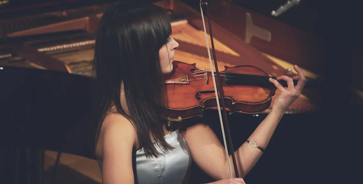 Woman sitting and playing the violin